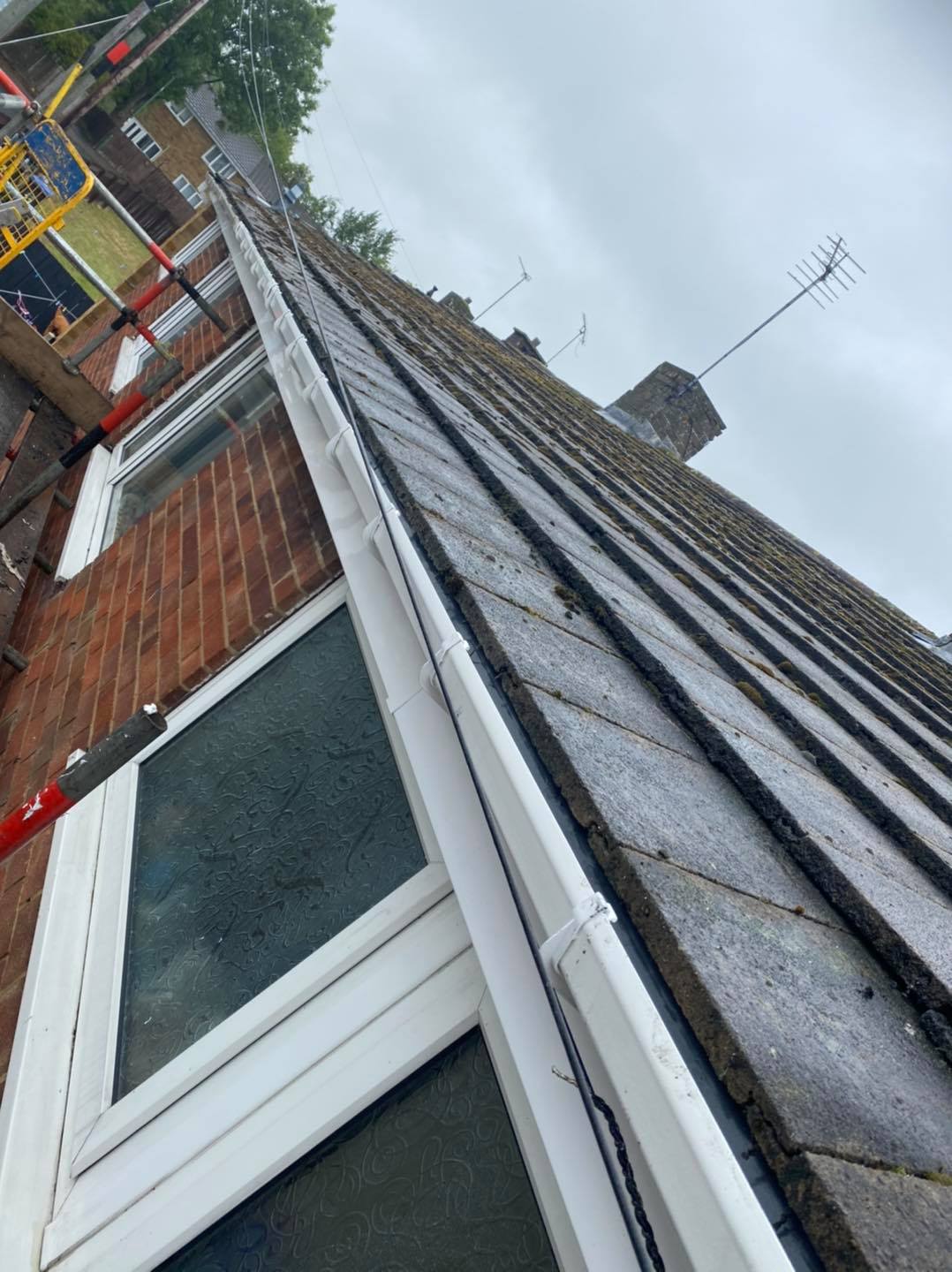 White guttering fitted along the edge of a tiled roof